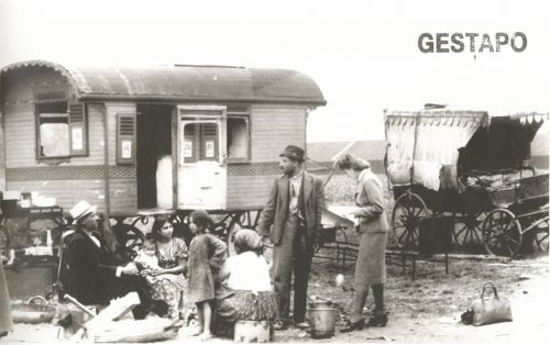 Roma-Familie und Frau in Kostüm vor einem Wohnwagen